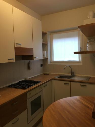 a kitchen with white cabinets and a sink and a window at IN PIAZZA appartamento con vista in Lazise