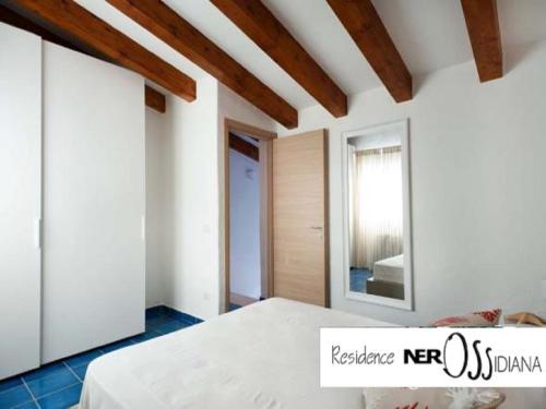 a bedroom with a bed and a mirror at NerOssidiana in Acquacalda
