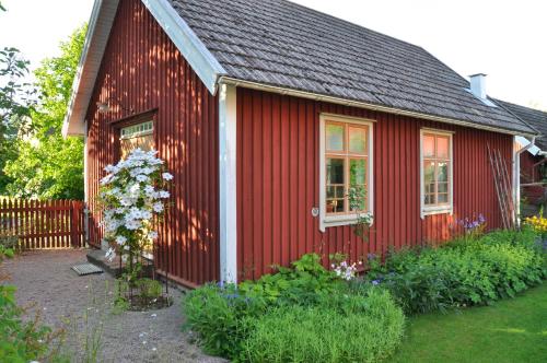 ein rotes Haus mit einem Garten davor in der Unterkunft Lilla Hotellet in Tranemo