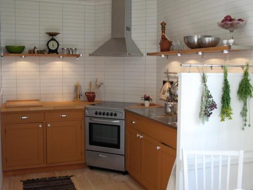 a kitchen with wooden cabinets and a stove top oven at Lilla Hotellet in Tranemo