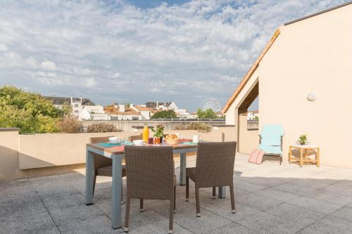 ラ・ロシェルにあるレジデンス ピエール ＆ バカンス サントルのバルコニーにテーブルと椅子が置かれたパティオ