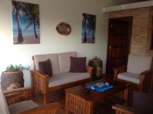 a living room with a couch and chairs and a table at Seashell Beach Villa in Grand'Anse Praslin