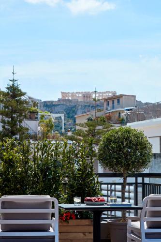 a table and chairs on a balcony with a view of a city at 18 Micon Str. in Athens