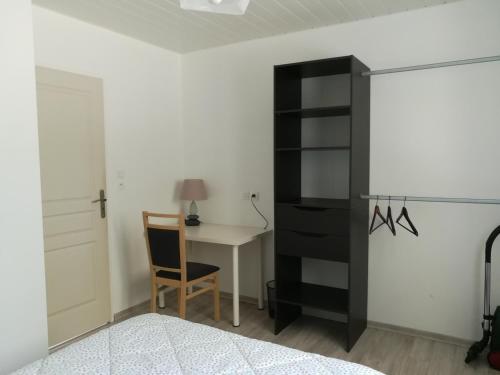 ein Schlafzimmer mit einem schwarzen Bücherregal neben einem Schreibtisch in der Unterkunft Appartement au calme in Saint-Maurice-de-Gourdans