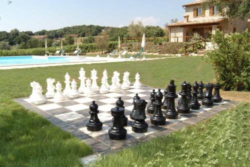 a chess board on a lawn next to a pool at Agriturismo Borgo Montecucco in Todi