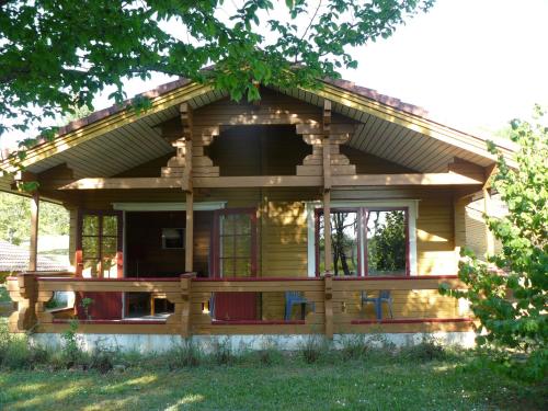 a log cabin with a porch and a window at Chalets du Soleil in Mauroux