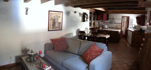 a living room with a blue couch and a kitchen at Charming House Óbidos in Óbidos