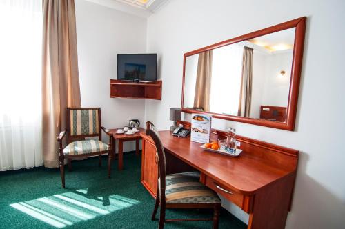 a hotel room with a desk and a mirror at Hotel Artur in Kraków