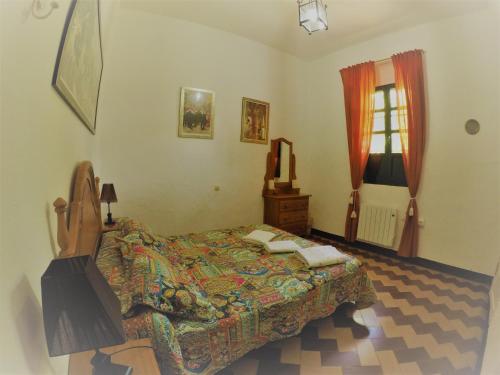 a bedroom with a bed and a window at Huerta La Cansina in Mairena del Alcor
