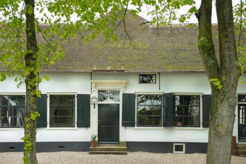 a white house with green shutters at De Heeren van Tuil in Tuil