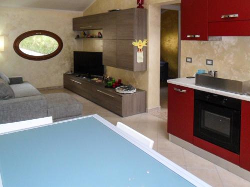 a kitchen and a living room with a couch and a table at La Mansarda Colorata in Rio Marina