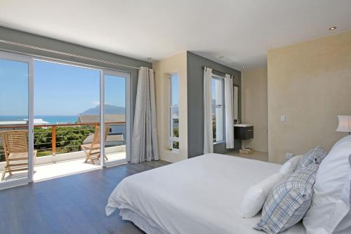 a bedroom with a bed and a view of the ocean at Greenways Drive Apartment in Kommetjie