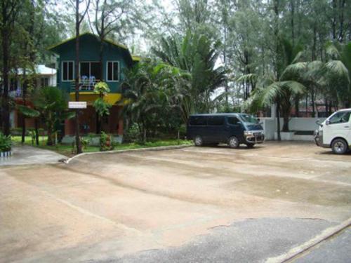 a parking lot with two cars parked in front of a house at Praasad Paradise in Cox's Bazar
