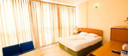 a bedroom with a bed and a large window at Praasad Paradise in Cox's Bazar