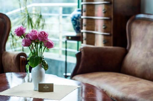 a vase of flowers sitting on a table with roses at Hotel Artur in Kraków