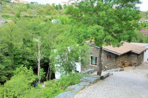 a small stone house in the middle of a forest at Moinho da Ponte Velha in Bragança