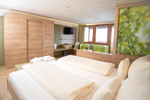 a hotel room with two beds and a television at Wellnesshotel Sonnenhof & Sonnhalde in Ühlingen-Birkendorf