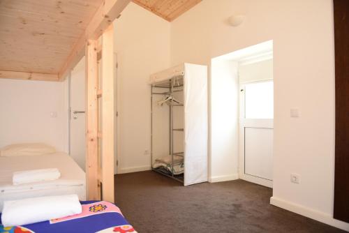 a small room with a bed and a closet at Horta do Vale - Nature House in Odeceixe
