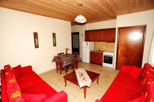 sala de estar con sofá rojo y mesa en Traditional Apartments Tsikrikonis, en Mirtófiton