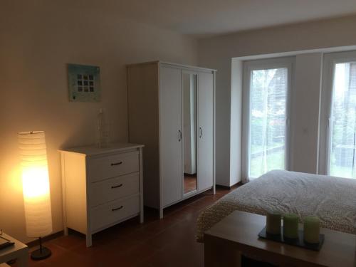 a bedroom with a bed and a dresser and a lamp at Cà Dela in Moghegno
