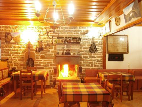 a restaurant with a fireplace and tables and chairs at Filira in Vitsa