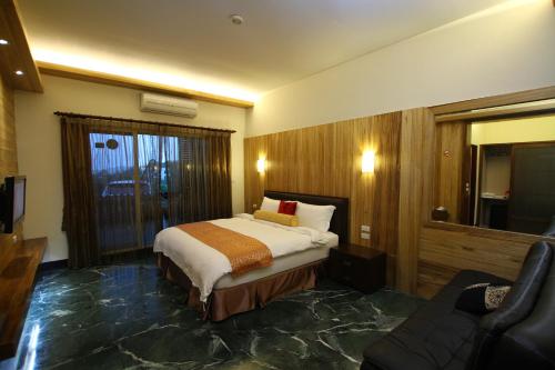 a hotel room with a bed and a couch at Water Moon山灣水月溫泉會館 in Yuli