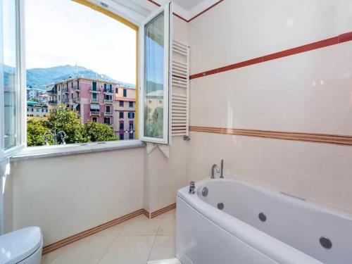 a bathroom with a tub and a window at Libra Flexyrent in Rapallo