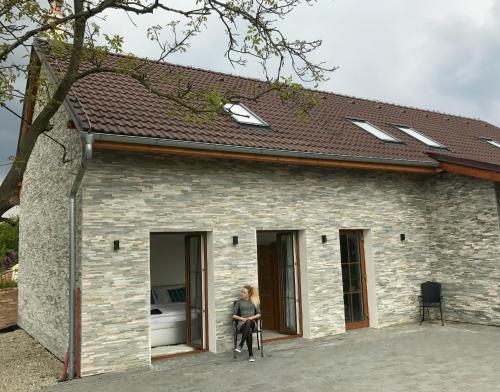a man sitting on the outside of a brick building at Apartmány U Ořecha in Bořetice