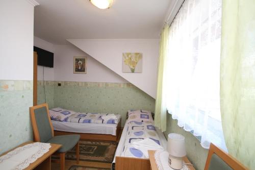 a room with two beds and a table and a window at Karolinka leba - FIRST MINUTE SEZON 2026!!! in Łeba