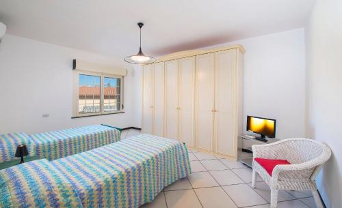 a bedroom with two beds and a chair and a window at HOUSE PIAZZA 24 in Pula