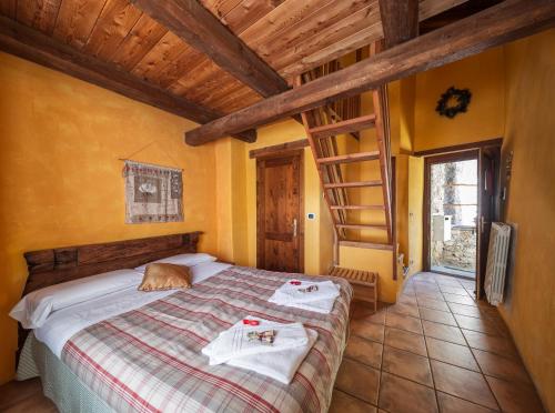 a bedroom with a bed with two towels on it at Locanda del Silenzio Hotel in Macra
