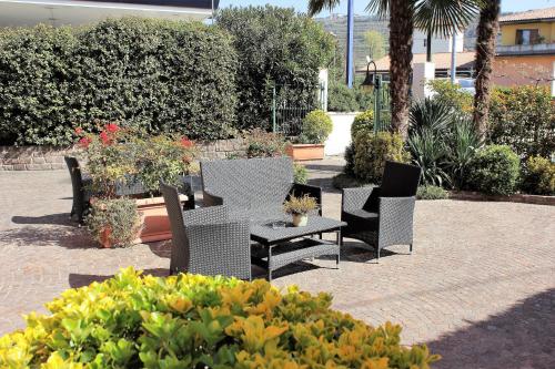 a patio with chairs and a table in a garden at Florivana Boutique Hotel in San Pietro in Cariano