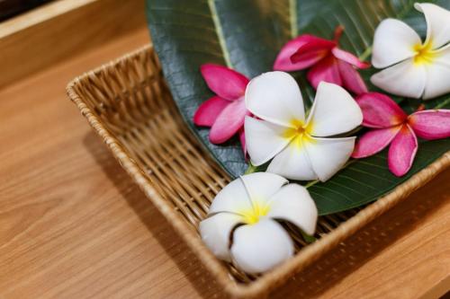 a bunch of flowers in a basket on a table at U Tiny Boutique Hotel Suvarnabhumi Bangkok - SHA Plus in Lat Krabang