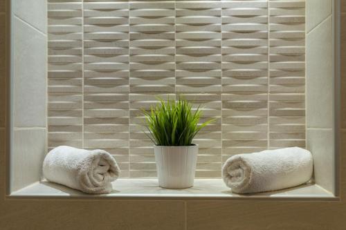 a bathroom with towels and a plant on a shelf at Luma Studio in Dubrovnik