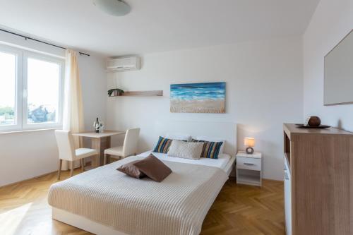a white bedroom with a bed and a desk and a window at Luma Studio in Dubrovnik