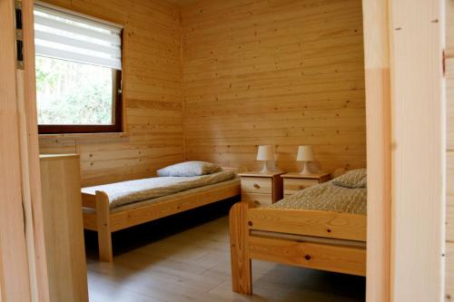 sypialnia z 2 łóżkami i oknem w obiekcie Alkado Domki Jurata w Juracie
