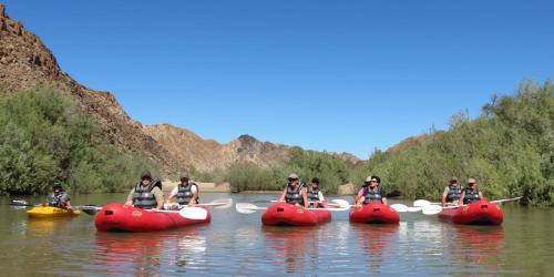 a group of people kayaking down a river in inflatable boats at Tutwa Desert Lodge in Augrabies