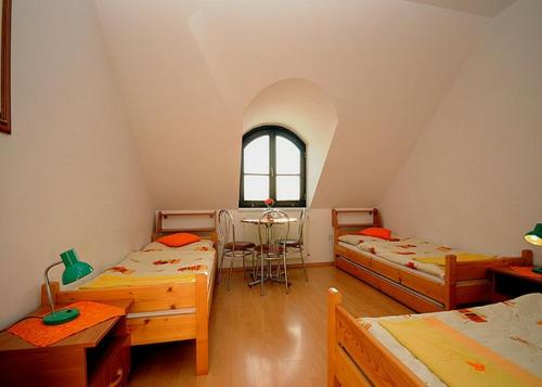 a room with three beds and a table in it at Penzión Centrál in Oščadnica