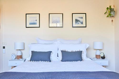 - une chambre avec un grand lit blanc et des oreillers bleus dans l'établissement The Potters Garden B&B, à Rye