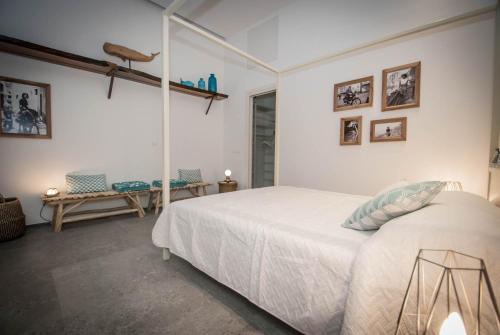 a white bedroom with a white bed and pictures on the wall at Luxury Apartments Manarola by Arbaspàa in Manarola