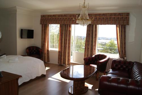 a bedroom with a bed and a table and chairs at Trudvang Gjestegaard in Larvik