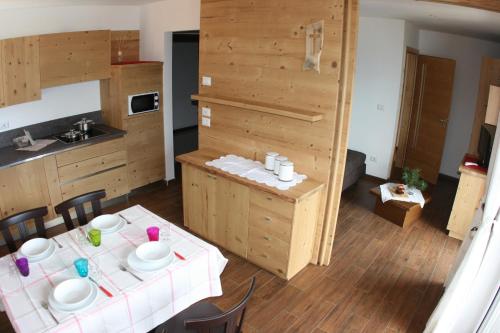 a kitchen with a table with plates and bowls on it at A. Paolo Apartments in Vigo di Fassa