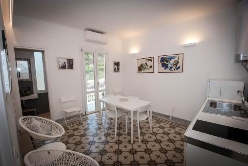 a kitchen with a white table and chairs at Luxury Apartments Manarola by Arbaspàa in Manarola