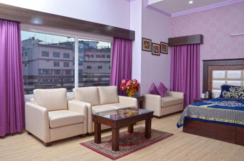 - une chambre avec un lit, deux chaises et une table dans l'établissement Hotel Shikhar & Restaurant, à Almora