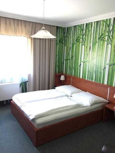 a bedroom with a bed with a green wallpaper at Europa Hotel És Étterem in Nyíregyháza