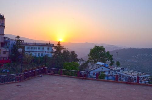 a view of the sunset from a balcony at Hotel Shikhar & Restaurant in Almora