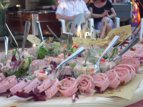 a table topped with different types of food with tongs at Hotel Sandra in Rimini