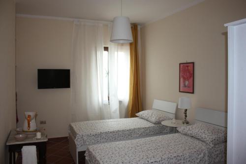 a hotel room with two beds and a window at B&B LA MARCHESA in SantʼAnastasia
