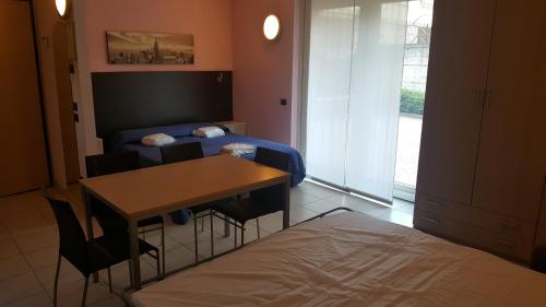 a room with a bed and a table and a desk at Residenza Villa Regina in Monza