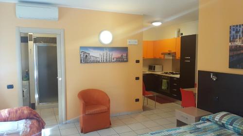 a living room with a chair and a kitchen at Residenza Villa Regina in Monza